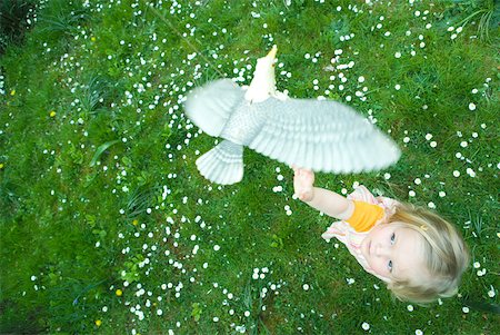 seagull looking down - Toddler girl reaching for toy bird, high angle view Stock Photo - Premium Royalty-Free, Code: 633-01715837