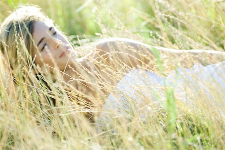 Young woman lying in field, relaxing Stock Photo - Premium Royalty-Free, Code: 633-01715889