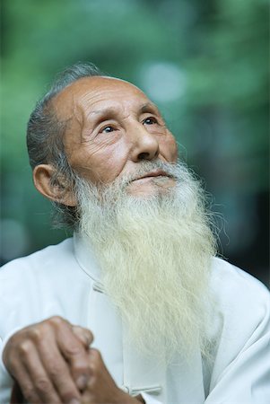 Elderly man in traditional Chinese clothing, looking up, portrait Stock Photo - Premium Royalty-Free, Code: 633-01715906