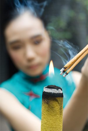 simsearch:633-02885727,k - Jeune femme vêtue de bâtons d'éclairage des vêtements traditionnels chinois de l'encens Photographie de stock - Premium Libres de Droits, Code: 633-01715941