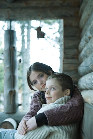 Teen girl sitting with arm around younger brother, both wearing warm sweaters Stock Photo - Premium Royalty-Free, Code: 633-01713698