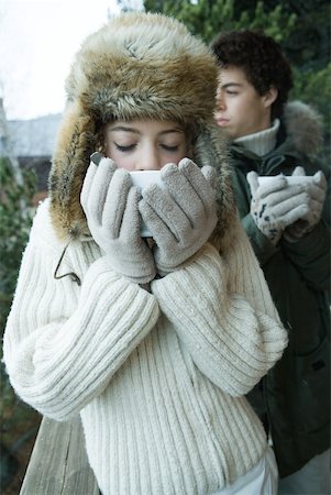 Teen boy and girl in winter clothes drinking warm drinks Stock Photo - Premium Royalty-Free, Code: 633-01713704