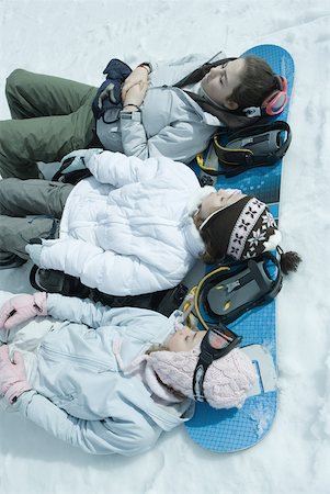 simsearch:696-03401844,k - Three sisters lying on snow with heads resting on snowboard Stock Photo - Premium Royalty-Free, Code: 633-01713725