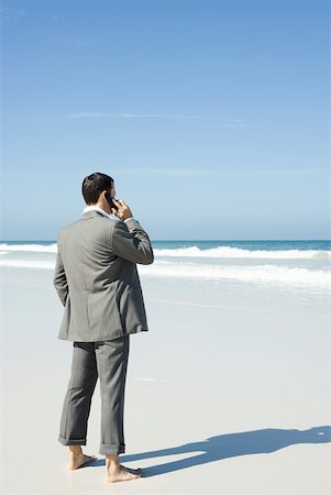 simsearch:633-01713848,k - Homme d'affaires pieds nus sur la plage, à l'aide de téléphone portable Photographie de stock - Premium Libres de Droits, Code: 633-01713794