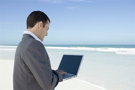 simsearch:633-01713826,k - Businessman standing on beach, using laZSop Stock Photo - Premium Royalty-Free, Code: 633-01713792