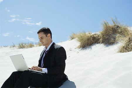 simsearch:633-01713826,k - Businessman sitting on sand dune, using laZSop Stock Photo - Premium Royalty-Free, Code: 633-01713809