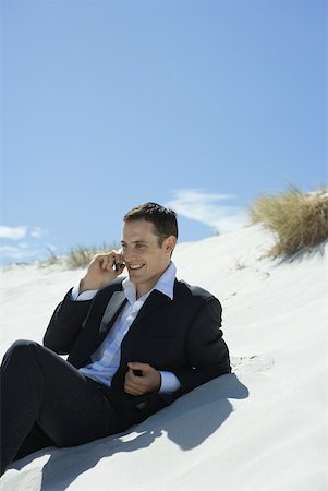 simsearch:633-01574593,k - Businessman sitting on sand dune, using cell phone Stock Photo - Premium Royalty-Free, Code: 633-01713815