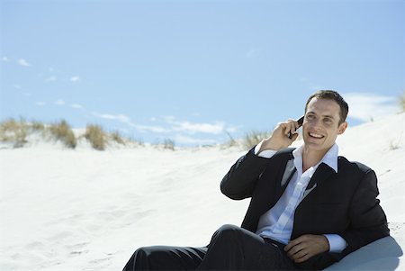 simsearch:633-01574322,k - Businessman sitting on sand dune, using cell phone Stock Photo - Premium Royalty-Free, Code: 633-01713816
