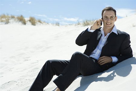 simsearch:633-01574593,k - Businessman sitting on sand dune, using cell phone Stock Photo - Premium Royalty-Free, Code: 633-01713817