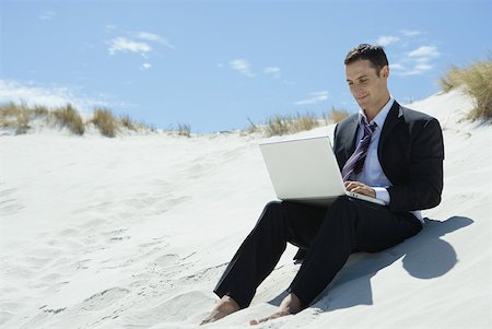 simsearch:633-01713826,k - Businessman sitting on sand dune, using laZSop Stock Photo - Premium Royalty-Free, Code: 633-01713810