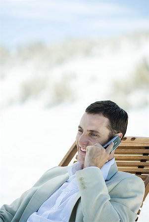 simsearch:633-01574593,k - Businessman sitting in deck chair at beach, using cell phone Stock Photo - Premium Royalty-Free, Code: 633-01713831