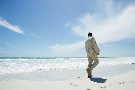 Homme d'affaires de marcher pieds nus sur la plage, vue arrière Photographie de stock - Premium Libres de Droits, Code: 633-01713854