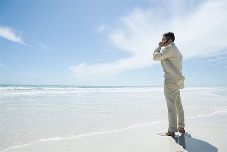 simsearch:633-01574593,k - Businessman standing barefoot on beach, using cell phone Stock Photo - Premium Royalty-Free, Code: 633-01713856