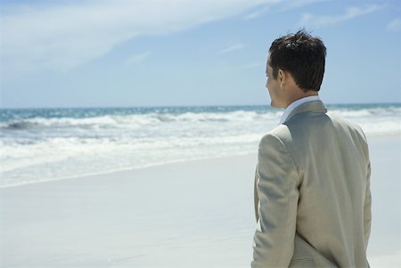 simsearch:696-03395430,k - Businessman standing on beach, looking at ocean, waist up Foto de stock - Royalty Free Premium, Número: 633-01713853