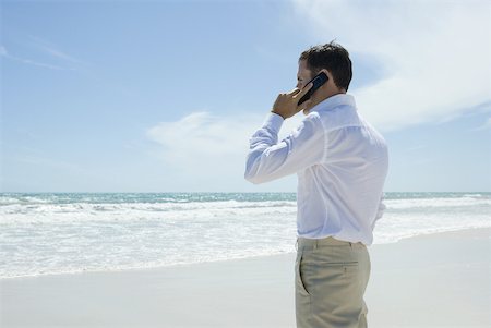 simsearch:633-01574593,k - Businessman using cell phone on beach, side view Stock Photo - Premium Royalty-Free, Code: 633-01713860