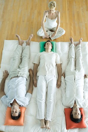 simsearch:633-02128630,k - Alternative therapy session, three adults lying side by side while therapist puts hands out over man's head Foto de stock - Sin royalties Premium, Código: 633-01713894