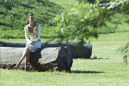 simsearch:633-01572611,k - Woman sitting on tree trunk, full length, looking away Stock Photo - Premium Royalty-Free, Code: 633-01713930