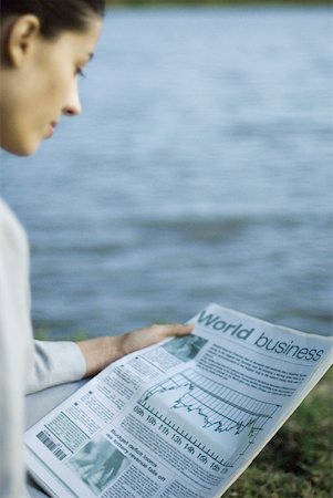 Businesswoman reading newspaper, lake in background Stock Photo - Premium Royalty-Free, Code: 633-01713944