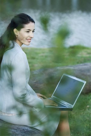 simsearch:633-01573622,k - Woman using laZSop in park, lake in background Fotografie stock - Premium Royalty-Free, Codice: 633-01713941