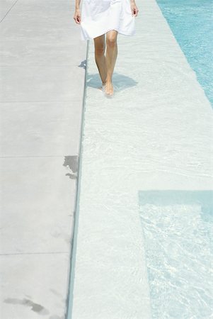 skirt from above - Woman walking on shallow swimming pool ledge, cropped view Stock Photo - Premium Royalty-Free, Code: 633-01837148