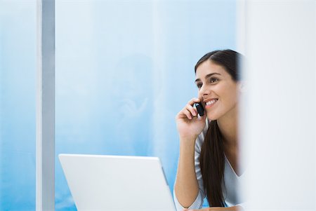 simsearch:632-02745019,k - Woman using cell phone and laZSop, smiling, cropped view Stock Photo - Premium Royalty-Free, Code: 633-01837181