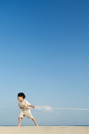 Little boy playing tug-of-war outdoors, side view Stock Photo - Premium Royalty-Free, Code: 633-01837249