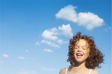 Little outdoors with tousled hair, eyes closed, smiling Stock Photo - Premium Royalty-Free, Code: 633-01837242