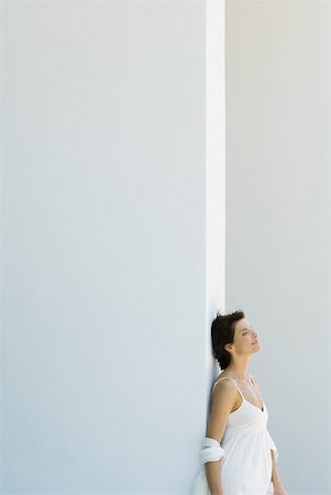 Woman leaning against wall, head back, eyes closed, side view Stock Photo - Premium Royalty-Free, Code: 633-01837256