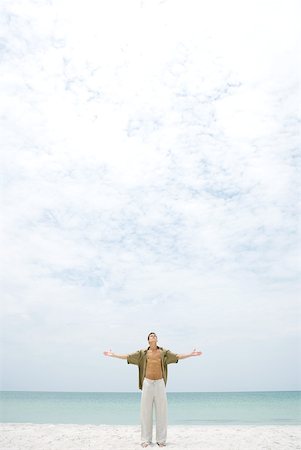 simsearch:696-03395430,k - Man standing on beach with head back and arms out, looking up at sky Foto de stock - Royalty Free Premium, Número: 633-01992647