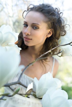 Young woman among flowering tree branches, smiling at camera Stock Photo - Premium Royalty-Free, Code: 633-01992751