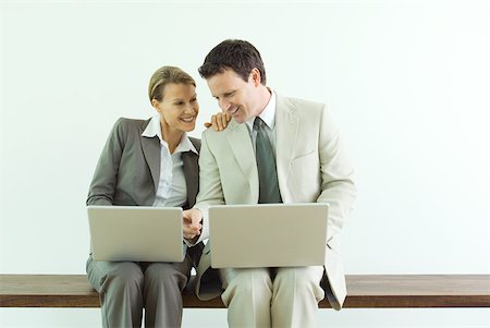 simsearch:633-02345800,k - Male and female business associates, both using laZSop computers, man pointing to woman's screen Stock Photo - Premium Royalty-Free, Code: 633-01992779