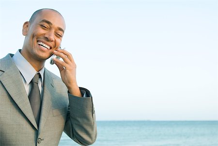 simsearch:633-01574593,k - Businessman at the beach using cell phone, smiling, eyes closed Stock Photo - Premium Royalty-Free, Code: 633-01992797
