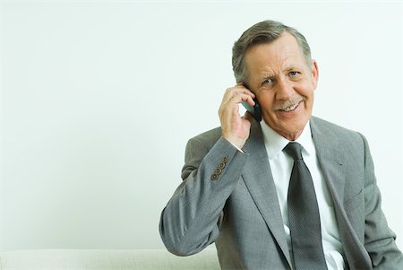 simsearch:633-01837165,k - Businessman using cell phone, smiling at camera Fotografie stock - Premium Royalty-Free, Codice: 633-01992798