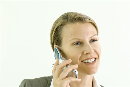 simsearch:695-03380514,k - Businesswoman using cell phone, smiling, close-up Fotografie stock - Premium Royalty-Free, Codice: 633-01992809