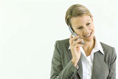 simsearch:695-03380514,k - Businesswoman using cell phone, smiling, looking down Stock Photo - Premium Royalty-Free, Code: 633-01992800