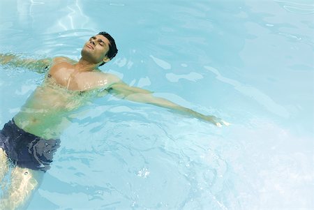 simsearch:632-07161660,k - Man floating on back in swimming pool with arms out, eyes closed Stock Photo - Premium Royalty-Free, Code: 633-01992912