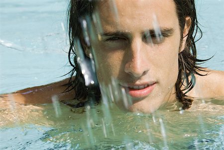 simsearch:696-03400450,k - Man in swimming pool, looking at camera through splashing water, close-up Stock Photo - Premium Royalty-Free, Code: 633-01992958