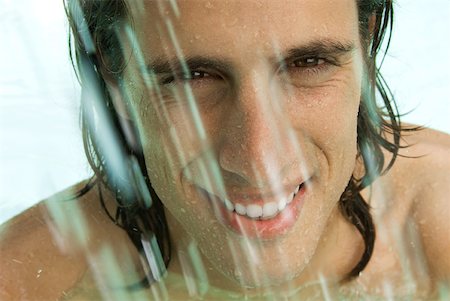 simsearch:696-03400450,k - Man splashing in swimming pool, smiling at camera, close-up Stock Photo - Premium Royalty-Free, Code: 633-01992960