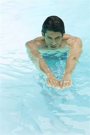 simsearch:633-01837165,k - Man swimming in pool, arms out, high angle view Fotografie stock - Premium Royalty-Free, Codice: 633-02044318