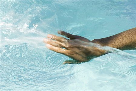 Man touching water's surface, cropped view of hand Stock Photo - Premium Royalty-Free, Code: 633-02044311