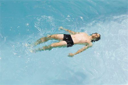 simsearch:632-07161660,k - Man floating on back in swimming pool, high angle view Stock Photo - Premium Royalty-Free, Code: 633-02044323