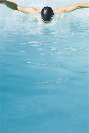 simsearch:632-03779312,k - Swimmer doing butterfly stroke in pool Foto de stock - Sin royalties Premium, Código: 633-02044332
