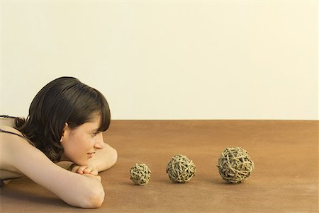 Woman resting head on arms, looking at balls of string, side view Stock Photo - Premium Royalty-Free, Code: 633-02044570