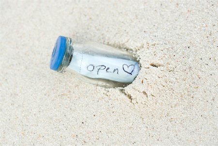 Message in a bottle, half buried in sand Stock Photo - Premium Royalty-Free, Code: 633-02065850