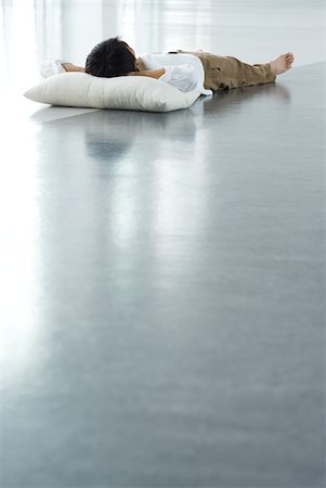 floor cushion - Man lying on floor with head on pillow, full length Stock Photo - Premium Royalty-Free, Code: 633-02065893