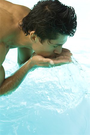 simsearch:400-04391064,k - Man bending over swimming pool, splashing water on face with hands, close-up Stock Photo - Premium Royalty-Free, Code: 633-02065991