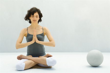 Woman sitting in lotus position beside ball, eyes closed Stock Photo - Premium Royalty-Free, Code: 633-02066067