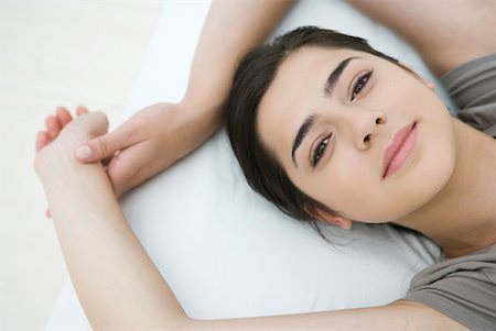 simsearch:633-01572611,k - Female lying on pillow, arms raised, smiling at camera Stock Photo - Premium Royalty-Free, Code: 633-02066106