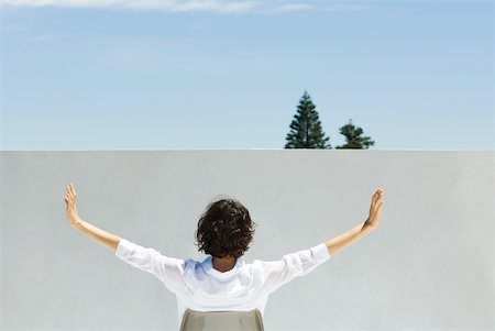 simsearch:633-02128680,k - Woman sitting outdoors, arms raised in the air, rear view Stock Photo - Premium Royalty-Free, Code: 633-02128604