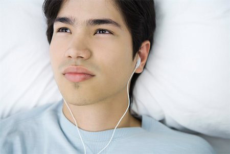 simsearch:633-01992734,k - Young man lying on back, listening to earphones, high angle view Foto de stock - Royalty Free Premium, Número: 633-02128681